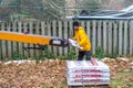 Man unloads shingles from a portable conveyer