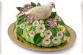 Colomba an Italian Easter dove cake with spring flowers on a white and green dish