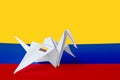 Colombia flag depicted on paper origami crane wing. Handmade arts concept