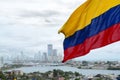 Colombian flag waving on the wind and modern Cartagena district