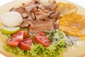 Colombian food, fried chicharron accompanied by salad, patacon and arepa