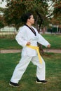 Colombian and Latin American woman practicing taekwondo defense in low left fist defense position