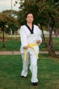 Colombian, Latin American woman practicing taekwondo with nunchakus right defense down