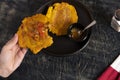 Colombian patacones dish with tomato sauce and onion hogao. Person eating traditional Latin dish. Banished trodden banana Royalty Free Stock Photo