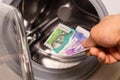 Colombian pesos being thrown into the washing machine, Concept, Money laundering, illegal activity, black market, Criminal