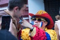 Colombian sport fan drawing russian flag on the cheek of the caucasian man sport fan at the street