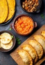 COLOMBIAN traditional food. Chicharron, maize arepas, fried empanadas, patacon with tomato and onion sauce. Top view Royalty Free Stock Photo