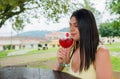 Colombian woman drinking a red cocktail outdoors. Royalty Free Stock Photo