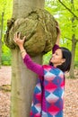 Woman holding cancerous tumor on beech tree