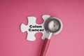 COLON CANCER text with Stethoscope on white jigsaw puzzle