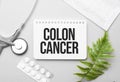 Colon Cancer word on notebook,stethoscope and green plant