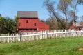 Colonial American village scene red wooden barn and white picket fence Royalty Free Stock Photo
