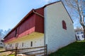 Colonial American whitewashed stone barn with red wood trim Royalty Free Stock Photo