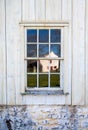Colonial barn reflected in antique twelve pane window