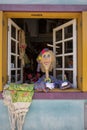 Colonial Brazilian house with decorations and objects. Brazilian decorative woman. Colorful Namoradeira figurine at window as Royalty Free Stock Photo