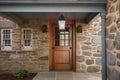 colonial house exterior with stone wall, wooden door, and lantern