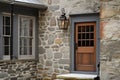 colonial house exterior with stone wall, wooden door, and lantern