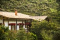 Colonial House between green mountains with red flowers in Antioquia Colombia. Traditional housing in the countryside.