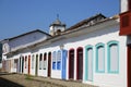 Typical house facades in sunshine with colorful doors and windows, in the background church steeple in historic town Paraty, Royalty Free Stock Photo