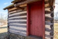 Colonial Pennsylvania log cabin exterior with red door