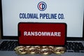 Colonial Pipeline Co logo on the blurred background and word RANSOMWARE on the smartphone in front. Stafford, United Kingdom, May