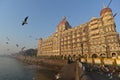 Colonial style hotel in Mumbai in early morning light with flocks of birds