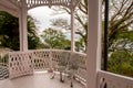 Colonial style wooden pink terrace in Glover Gareden with old stylish chairs and trees in the background, Nagasaki, Japan. Royalty Free Stock Photo