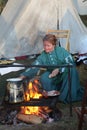 Colonial woman cooking over a fire