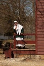 a colonial woman on the porch of her house