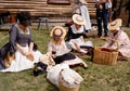 Colonial women and children have lunch on the grass outside the Captain William Smith house