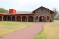 Colonnial farm and country house, stone and red brick construction with arches and green grass garden Royalty Free Stock Photo