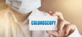 Colonoscopy word written on card in hand of Medical Doctor. Healthcare concept