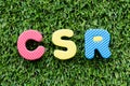 Color alphabet letter in word CSR Abbbreviation of corporate social responsibility on green grass background