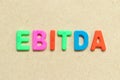 Color letter with word EBITDA abbreviation of earnings before interest, taxes, depreciation and amortization on wood