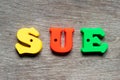 Color letter in word sue on wood background