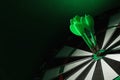 Color arrows hitting target on dart board against green background Royalty Free Stock Photo