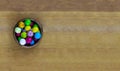 Color base of the holiday wooden bowl with rainbow gumballs view from above on a natural background board Royalty Free Stock Photo