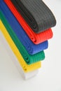 Colored belts in martial arts, and a part of judo uniform, for gray background Royalty Free Stock Photo