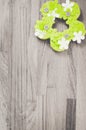 Color burst of green handmade Easter flower decoration on a grayscale wooden surface