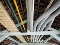 Color-coded electrical and utility pipes arranged neatly under a roof structure in an industrial setting Royalty Free Stock Photo
