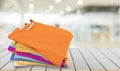 Stack of colorful t-shirts on wooden table