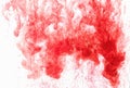 Color ink drop in water, photographed in motion, swirling. Red icloud of paint on white background. Royalty Free Stock Photo