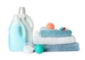 Color dryer balls, detergents and stacked clean towels on white background
