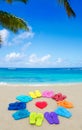 Color flip flops and heart on sandy beach