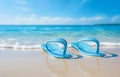 color flip-flops on white beach sand over blue transparent ocean Royalty Free Stock Photo