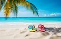 color flip-flops on white beach sand over blue transparent ocean
