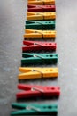 Color linen clothespins in row. Green, red and yellow plastic clothespins. Selective focus Royalty Free Stock Photo