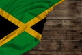 Color national flag of the modern state of Jamaica, beautiful silk, background old wood, concept of tourism, economy, politics,