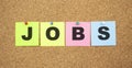 Color notes with letters pinned on a board. Word JOBS Royalty Free Stock Photo