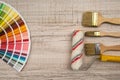 Color palette guide and paint brush roller  on wood board Royalty Free Stock Photo